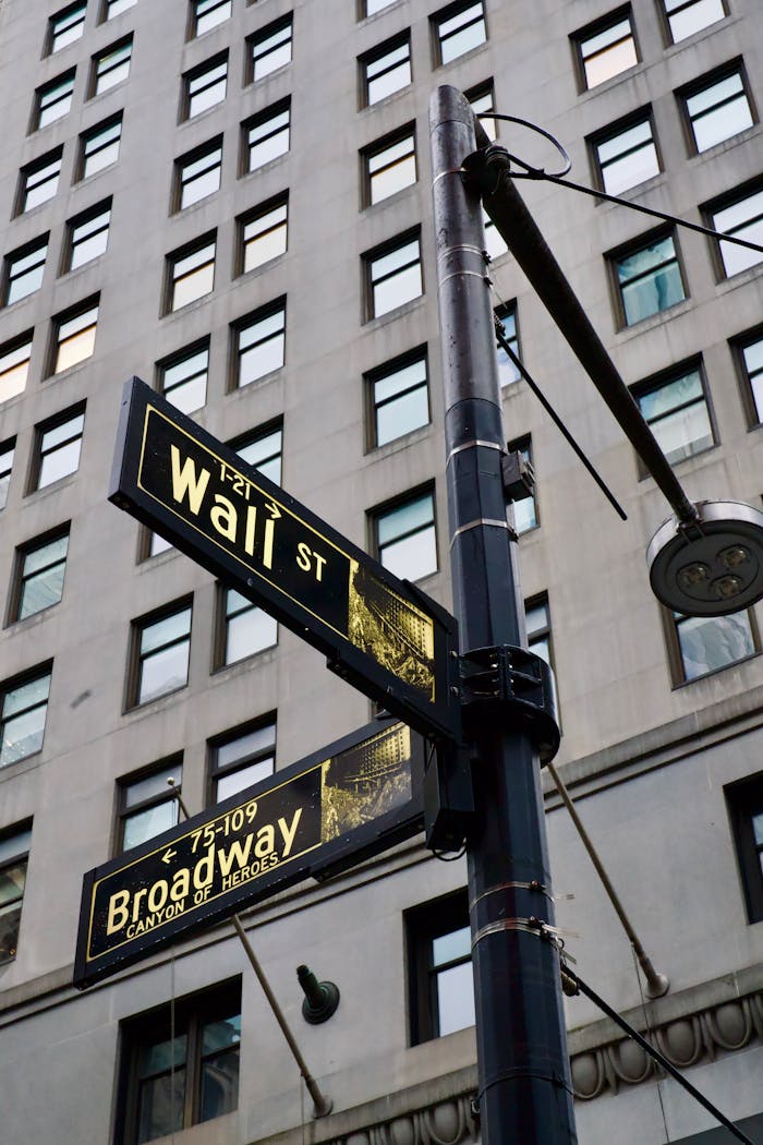Street signs at the intersection of Wall Street and Broadway in New York City.
