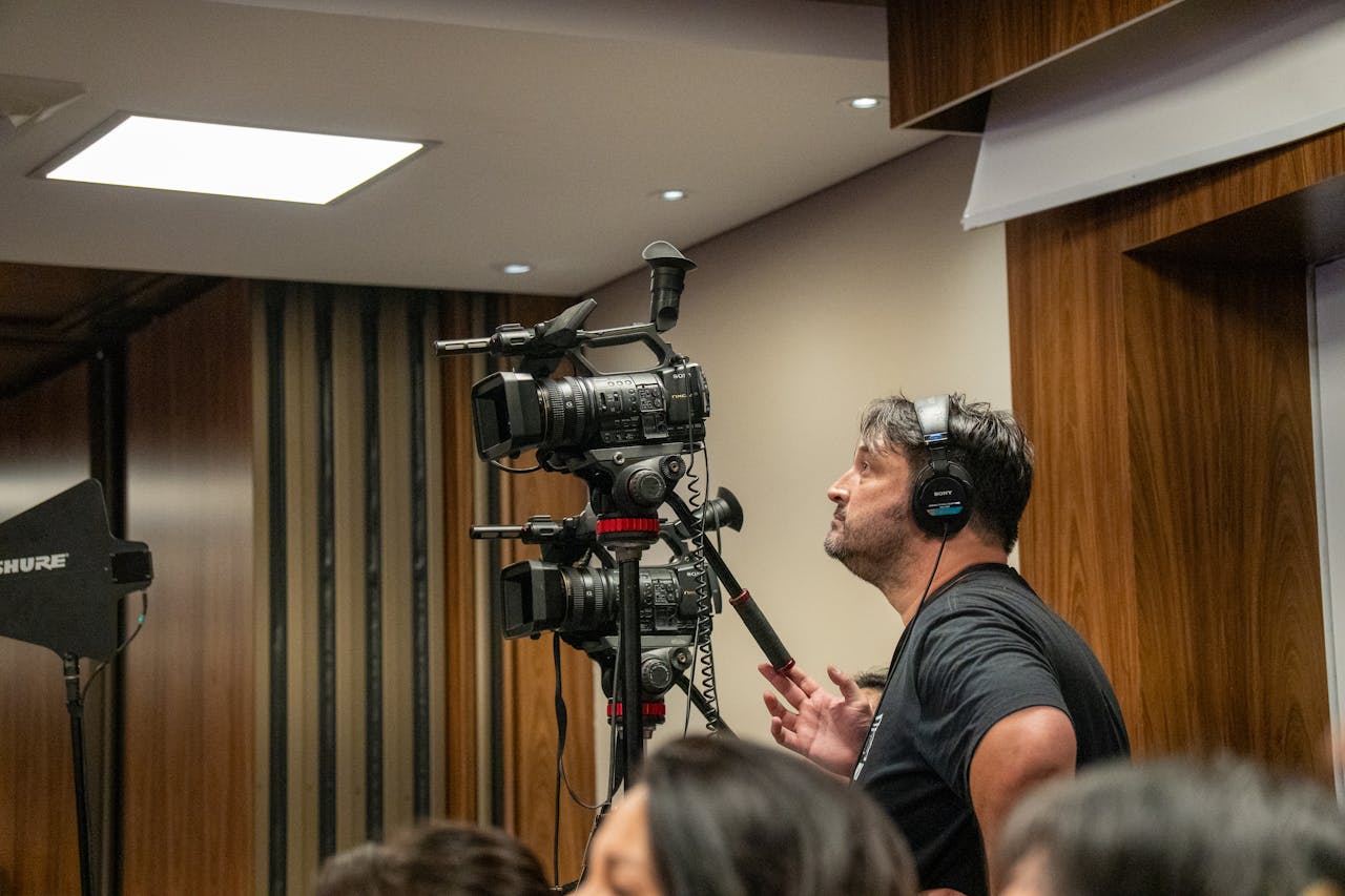 Cameraman operating professional video cameras during an indoor event. Perfect for media and broadcasting themes.